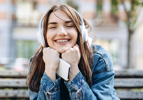 young-smiling-woman-listening-music-with-headphones_600